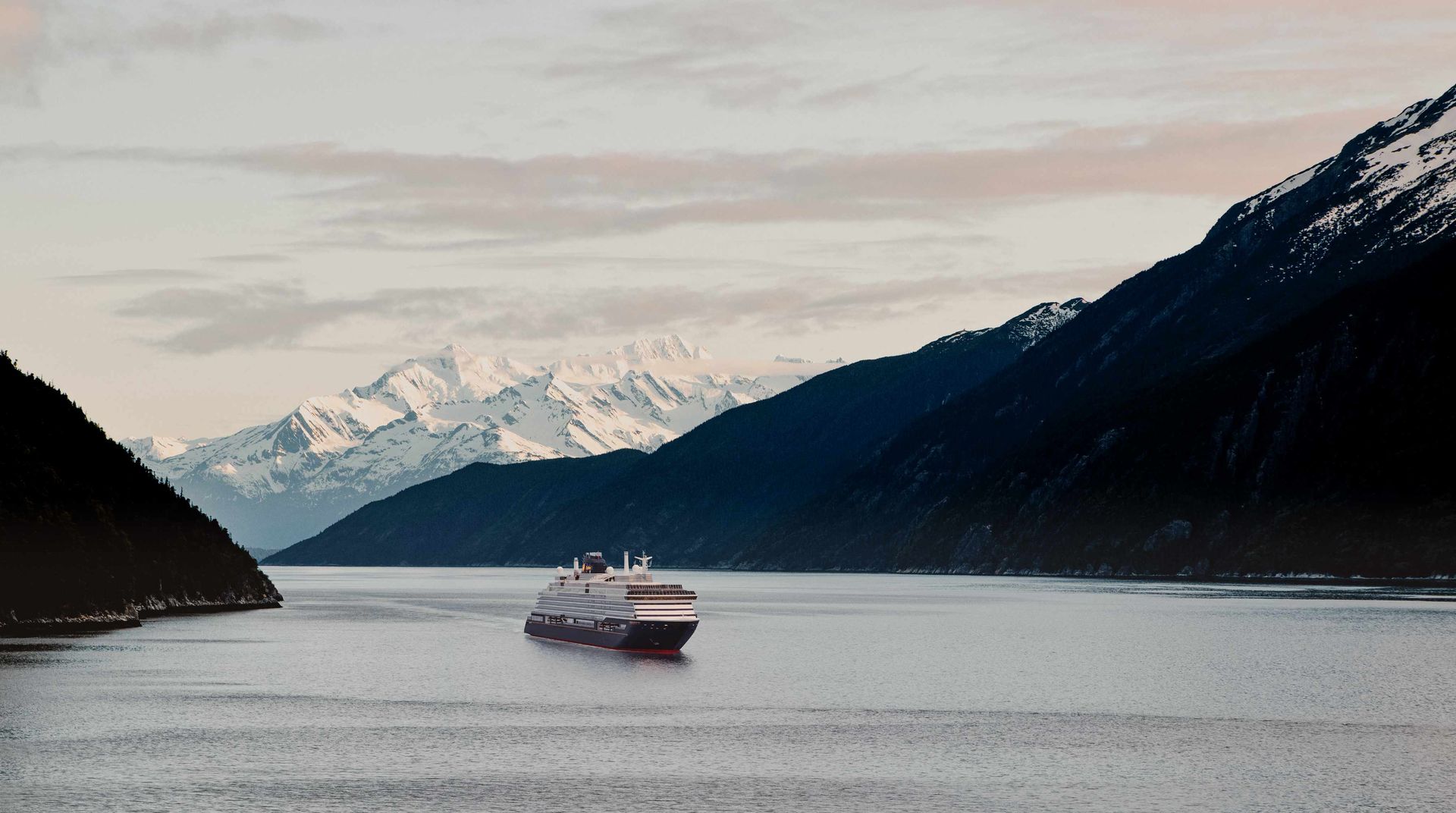 Explora Journeys ship sailing through an Alaska fjord